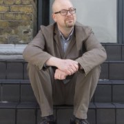 Image of a middle aged man sitting on pub steps