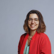 Mariana in a orange jacket, with glasses